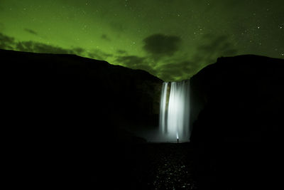 Scenic view of waterfall against sky at night