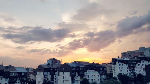 Low angle view of buildings against cloudy sky