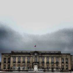 Low angle view of buildings against cloudy sky