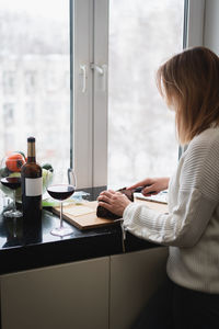 Side view of young woman working at table