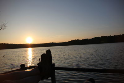 Rear view of silhouette people overlooking calm lake