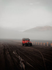 Car on road in desert against sky