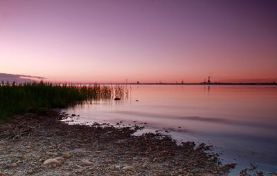 Scenic view of beach against clear sky during sunset