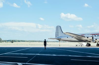 Man on runway by airplane against sky at berlin tempelhof airport