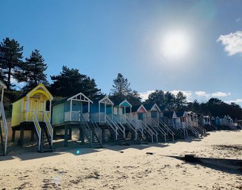 Chairs on beach against sky on sunny day