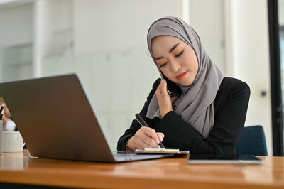 Young woman using laptop at office