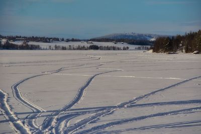 Snow covered field against sky