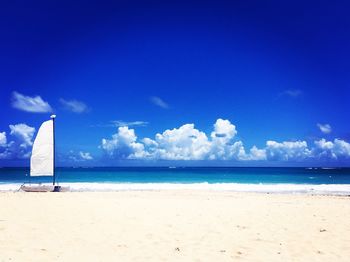 Scenic view of beach against blue sky