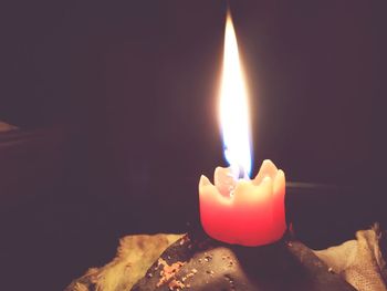 Close-up of burning candle in darkroom