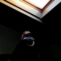 Low angle view of girl looking through window