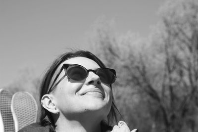 Portrait of young woman wearing sunglasses against sky