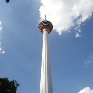 Low angle view of communications tower against cloudy sky