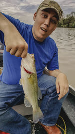 Portrait of man holding fish in boat