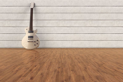 Electric guitar on hardwood floor against wall at home