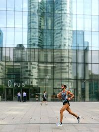 Full length of woman running in city
