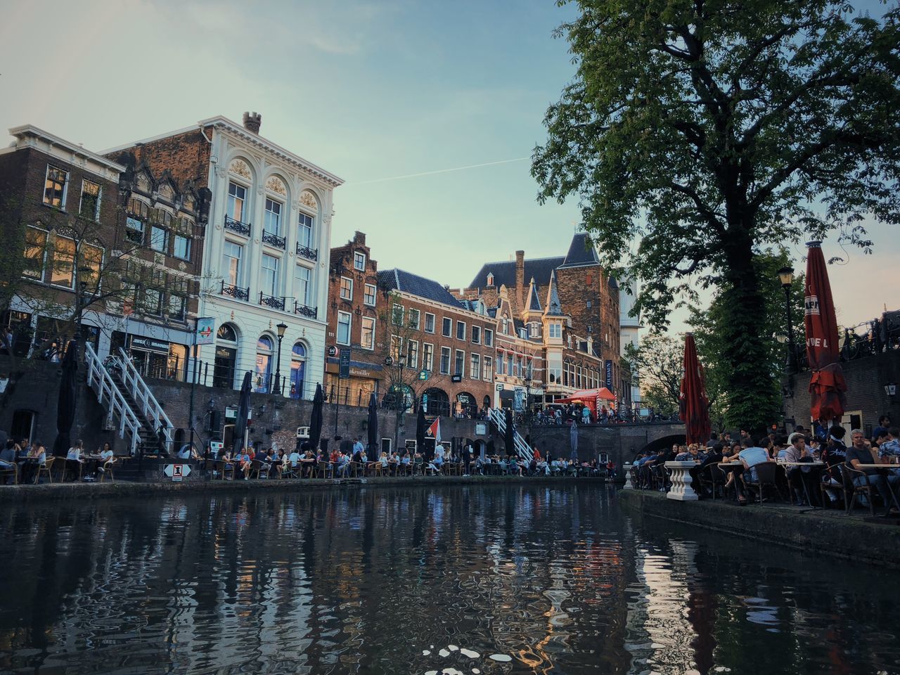 GROUP OF PEOPLE ON BUILDINGS BY CANAL