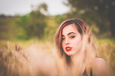 Portrait of young woman on field