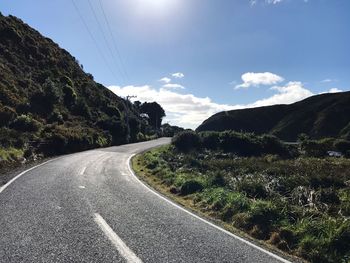 Road amidst trees against sky