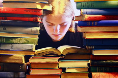 Teenage girl reading book in library