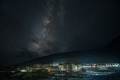 Illuminated buildings in city against sky at night