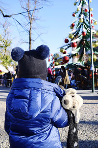 Rear view of woman with teddy bear