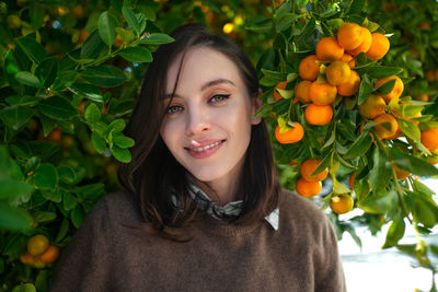 Portrait of young woman standing amidst plants