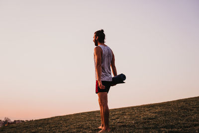 Man standing on field against clear sky