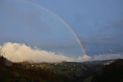 Rainbow over landscape against sky