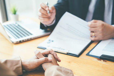 Midsection of man using mobile phone on table