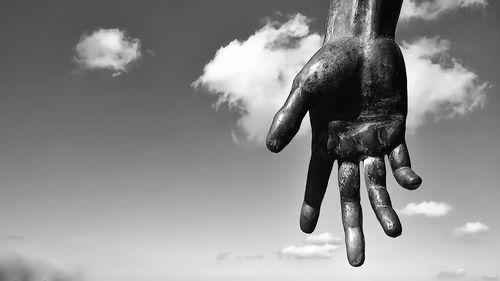 Hand sculpture against sky