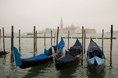 Gondolas moored on grand canal against clear sky