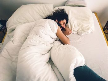 High angle view of man sleeping on bed