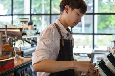 Side view of young man looking at restaurant