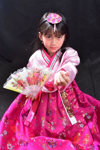 Portrait of cute girl with pink petals standing outdoors