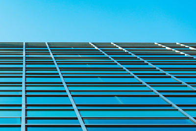 Low angle view of modern building against clear blue sky