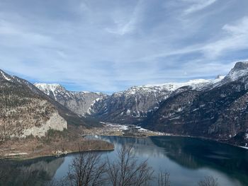 Scenic view of lake by snowcapped mountains against sky