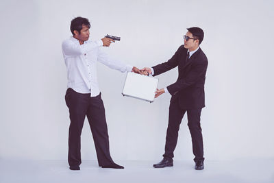 Young couple standing against white background