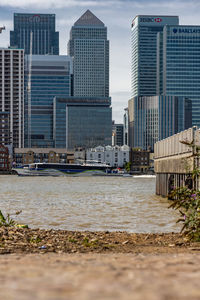 Modern buildings by sea against sky in city