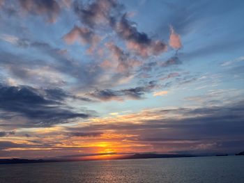 Scenic view of sea against dramatic sky during sunset