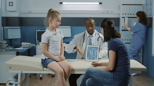 Female doctor examining patient in office