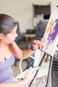 Side view of young woman using mobile phone