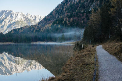 Scenic view of lake by mountains against sky