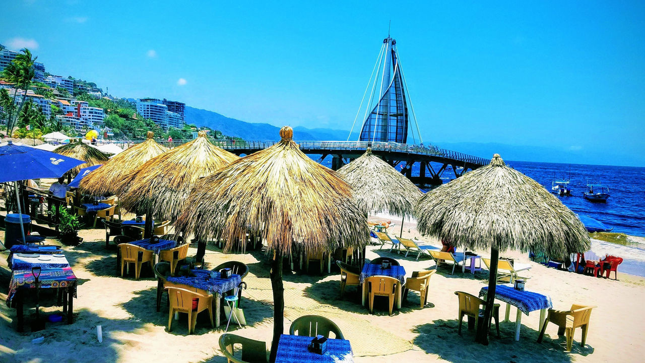 PANORAMIC VIEW OF LOUNGE CHAIRS ON BEACH