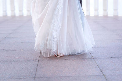 Low section of woman standing on footpath