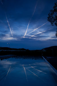 Scenic view of vapor trails in sky at dusk