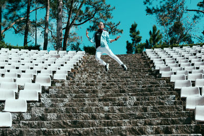 Excited man jumping on steps in stadium