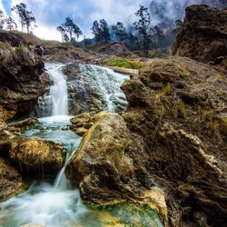 Scenic view of waterfall against sky