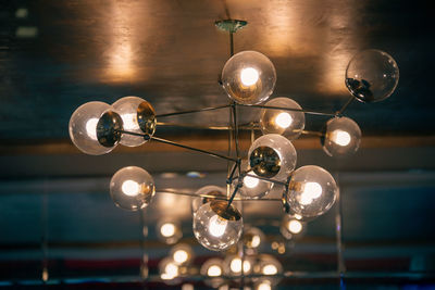 Low angle view of illuminated pendant lights hanging from ceiling