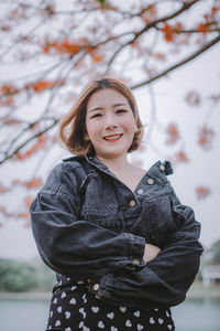 Smiling woman standing by flowering tree