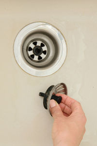 Close-up of woman holding drain of sink